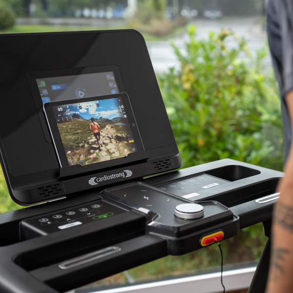 Close-up of the display showing a tablet on the cardiostrong TX50 Treadmill console.
