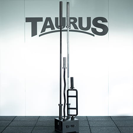 Various Taurus barbells racked vertically on Taurus Floor Stand.