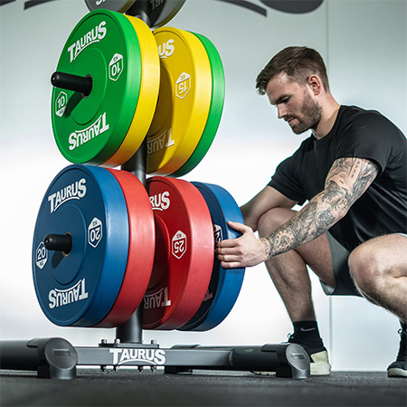 Person adjusting weight plates on the Taurus Elite Plate Tree