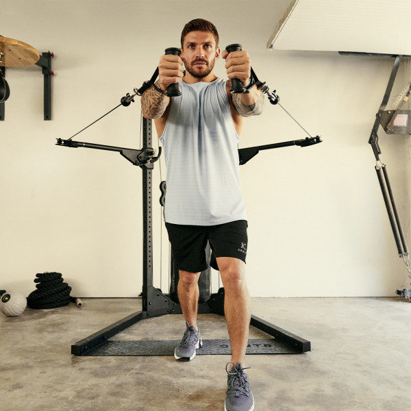 Performing a chest fly exercise on the Centr 1 Home Gym Functional Trainer.
