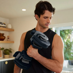 Person doing a bicep curl with the Centr Smart Stack 50 Adjustable Dumbbell.
