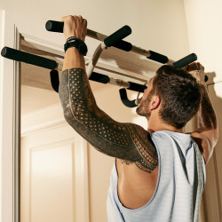 Person using Centr Bodyweight Training Kit pull-up bar for exercise.
