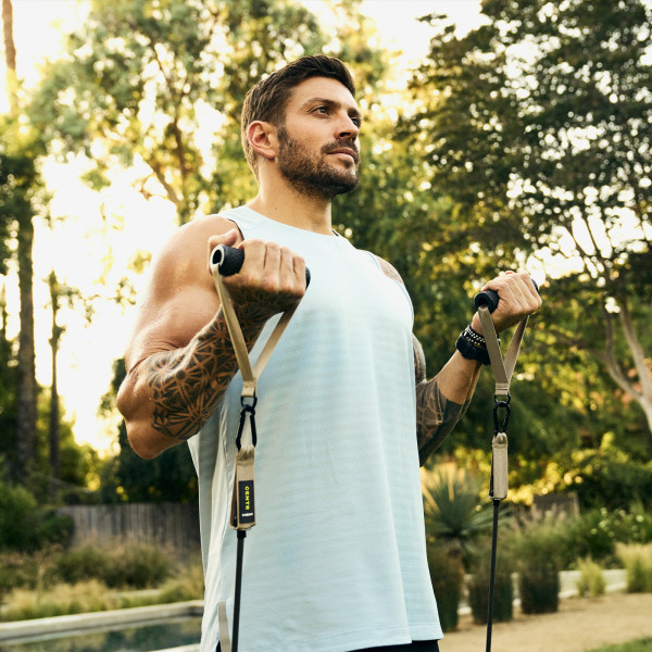 Lifestyle image of a model using the resistance bands as part of the Centr Workout Kit