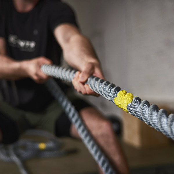 Lifestyle image of the CENTR x HYROX Competition Power Rope, its is a close up of a model performing a pull exercise.