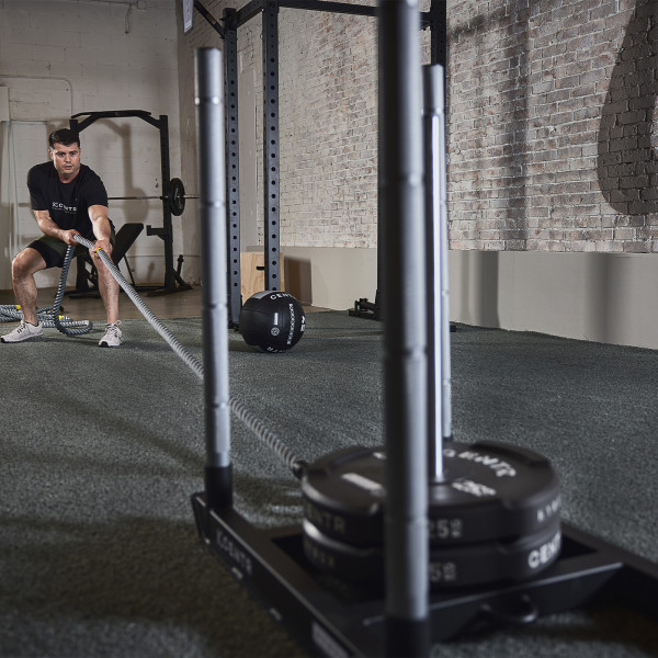 Lifestyle image of the CENTR x HYROX Competition Power Rope, the model is doing a pull exercise from a wide angle.