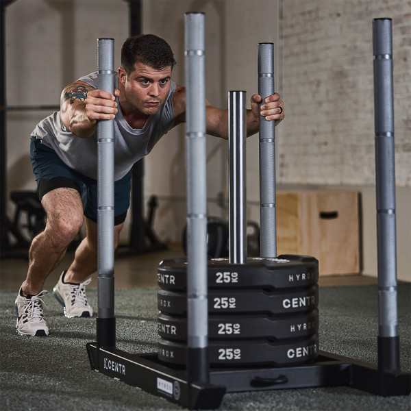 Lifestyle image of the CENTR x HYROX Competition Power Sled being pushed by a model.