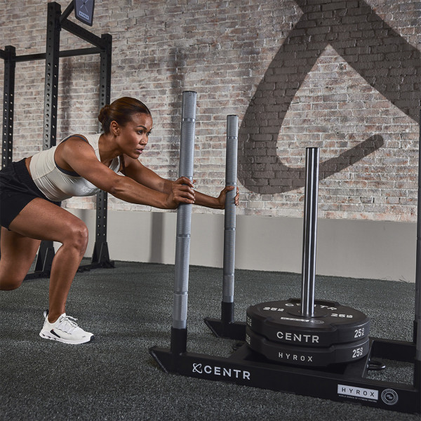 Lifestyle image of the CENTR x HYROX Competition Power Sled being pushed by a model.