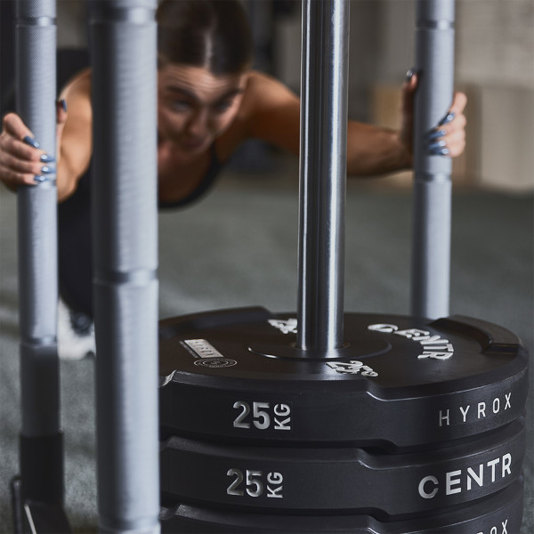 Close-up of CENTR x HYROX Bumper Plates during sled push.