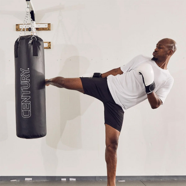 Model performing a side kick on the Century Traditional Hanging Heavy Bag