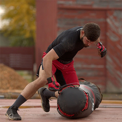 Image of a model mounting the Century Vs.1 punch bag for MMA style ground and pound.