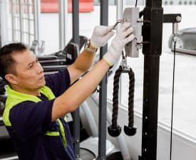 A person is working on a cable pull machine.