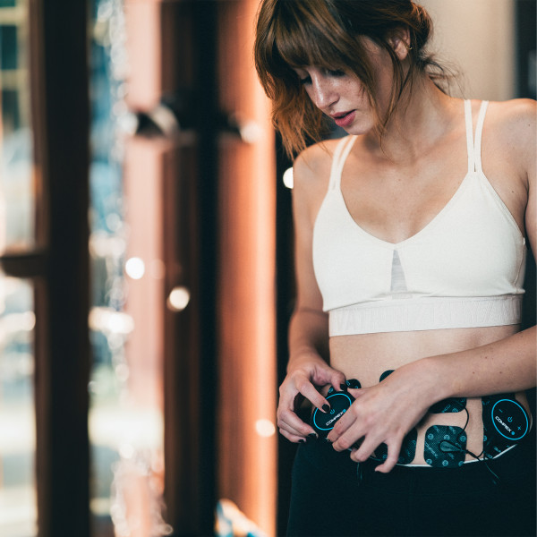 Lifestyle image of the Compex MINI TENS Muscle Stimulator - Model using on abs