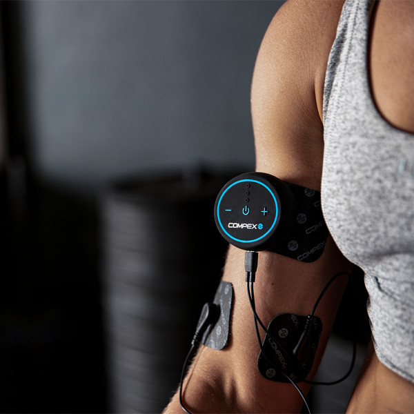 Lifestyle image of the Compex MINI TENS Muscle Stimulator - Model using EMS on biceps