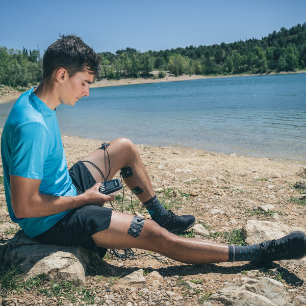 Lifestyle image of the Compex SP 2.0 - model using electrodes on leg