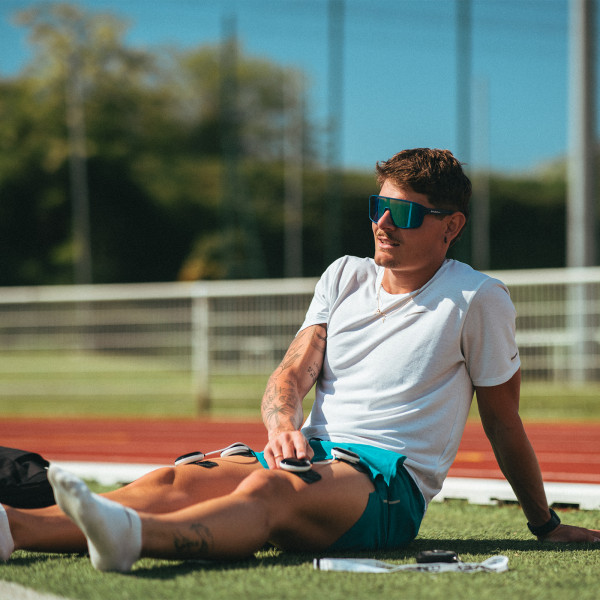 Lifestyle image of the Compex SP 8.0 - model has electrodes on their quads.