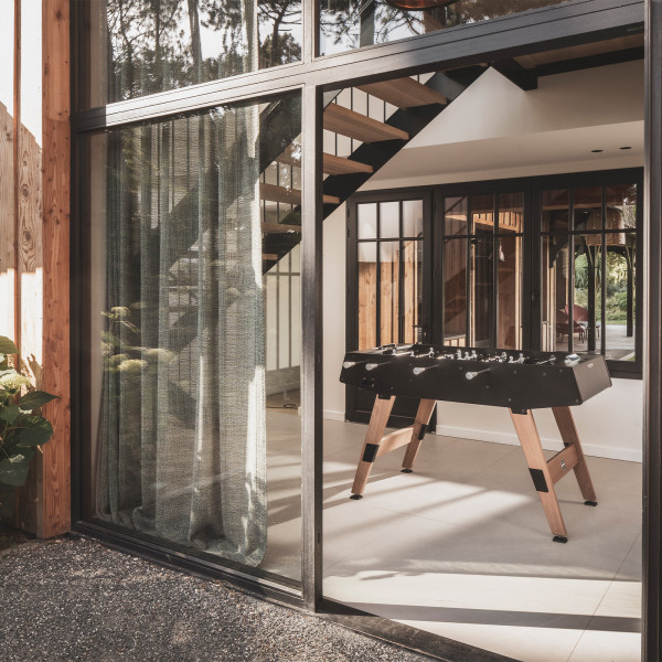 Cornilleau Play-Style Origin outdoor football table in black indoors near glass doors