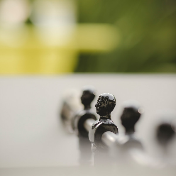 Row of black players on the Cornilleau Play-Style Origin outdoor football table in white
