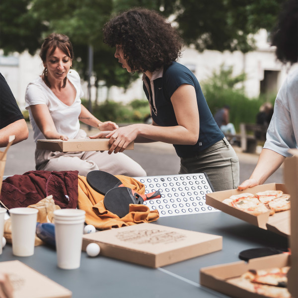 Friends enjoying food around the Cornilleau Urban Outdoor Table Tennis Table
