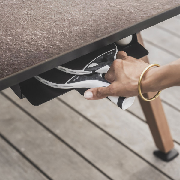 Storage drawer with rackets and balls under the black Cornilleau Play-Style Origin table