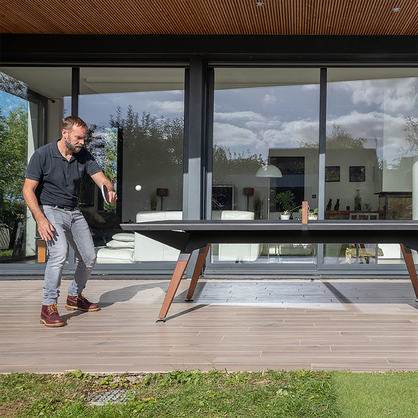 Person playing on the black Cornilleau Play-Style Origin Outdoor table