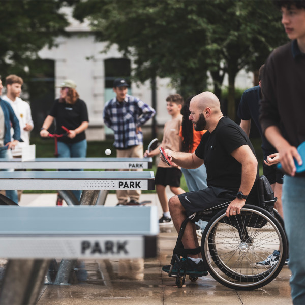Wheelchair user and standing player having a match on the Cornilleau Park Outdoor Table Tennis Table