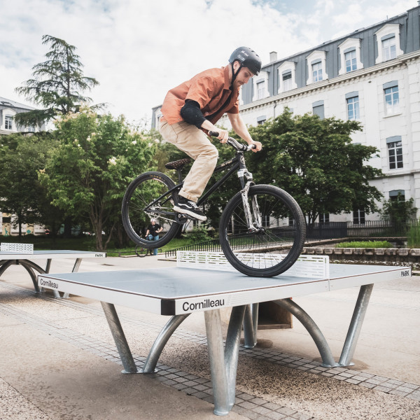 BMX trick being performed over the Cornilleau Park Outdoor Table Tennis Table