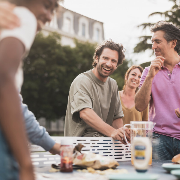 Friends enjoying food around the Cornilleau Park Outdoor Table Tennis Table