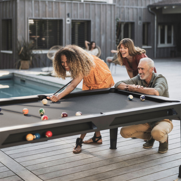 People enjoying a pool game on the Cornilleau Hyphen with black frame and dark grey cloth