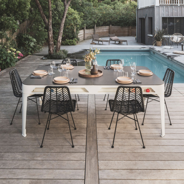 Outdoor dining setup using the Cornilleau Play-Style Hyphen pool table with six chairs by the pool