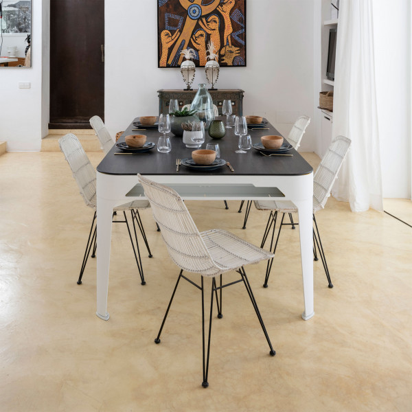 Indoor dining scene with six chairs around a Hyphen table dressed for dinner