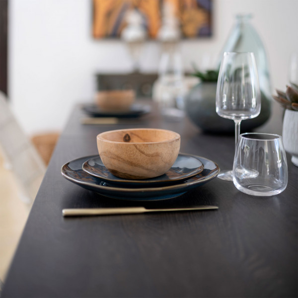 Close-up of a laid dining table with modern crockery and glassware on a Hyphen table top