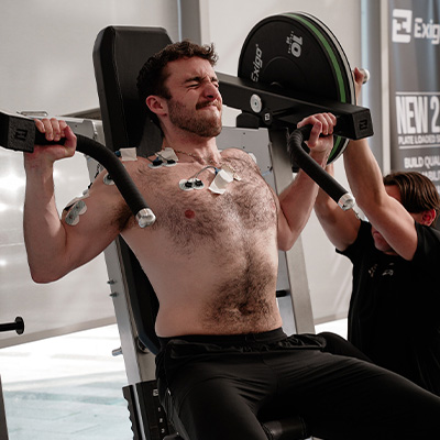 image of a model on a shoulder press being monitored by a scientist