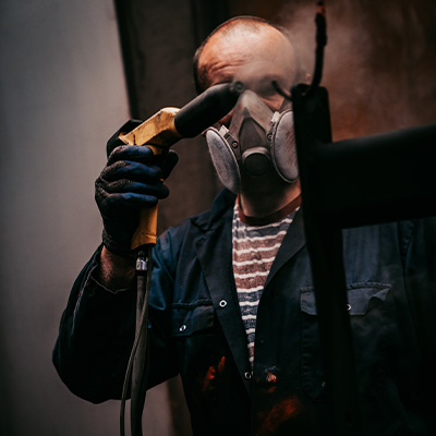 Image of an Exigo engineer spray painting a machine