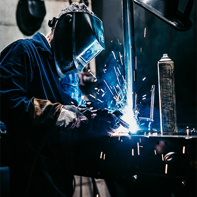 Image of a model welding some Exigo equipment.