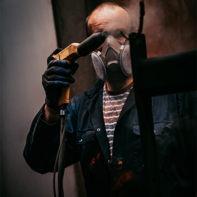 Photograph of a person spray painting Exigo equipment