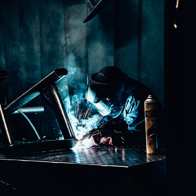 Image of a welder, welding an Exigo machine frame