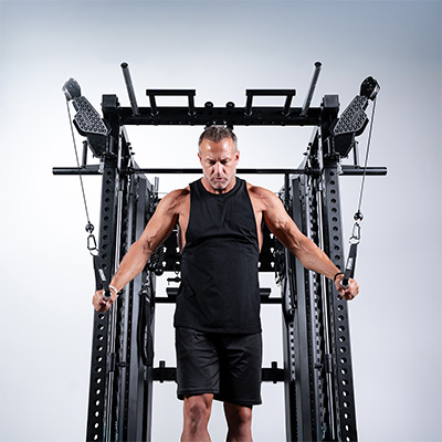 User performing standing cable crossover on Force USA C20 Trainer