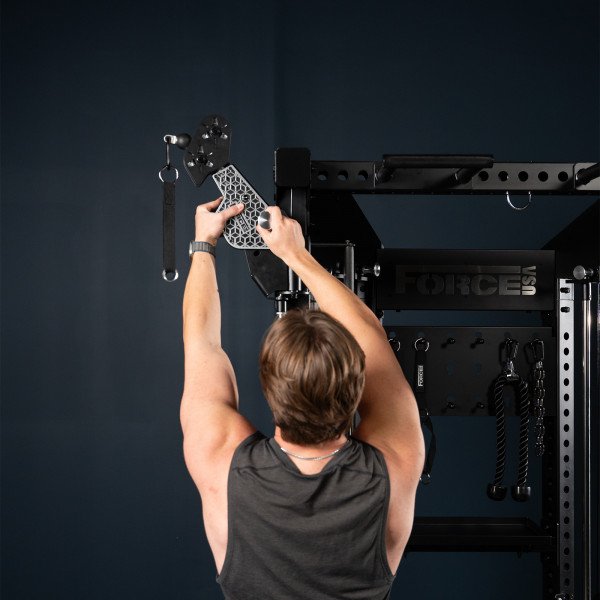 User adjusting attachment on the Force USA Functional Trainer Rack
