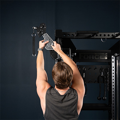User adjusting attachment on the Force USA Functional Trainer Rack