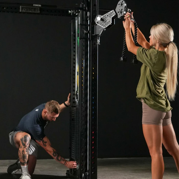 Lifestyle image of the Force USA M20 All-In-One Trainer - Image of a pair of modes adjusting the machine