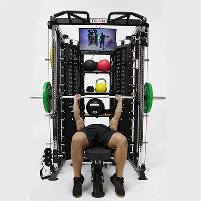 Model bench pressing inside the Force USA G15 All-In-One Trainer 
