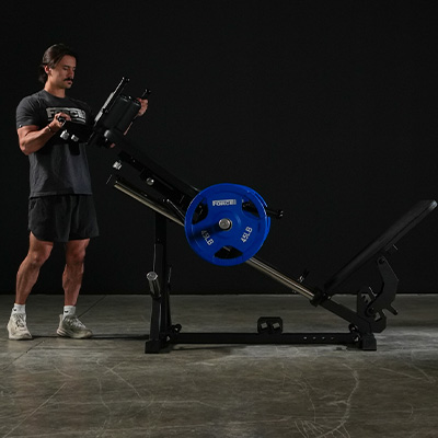 Image of a model adjusting the Force USA Compact Leg Press & Hack Squat