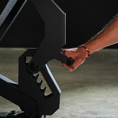 A close-up image of a model adjusting the Force USA Compact Leg Press & Hack Squat