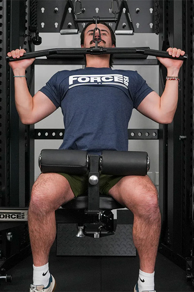 User performing lat pulldown on the Force USA Swivel Seat (front view)