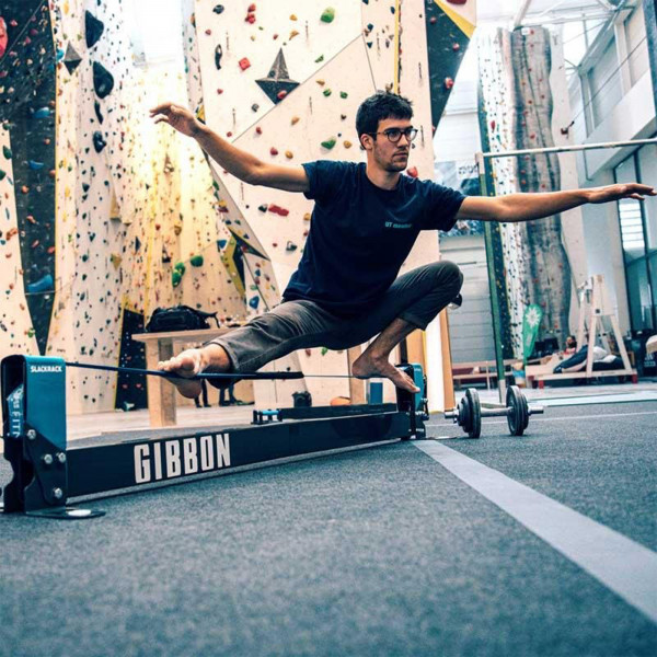 User squatting on the Gibbon Slackrack Fitness in a climbing centre