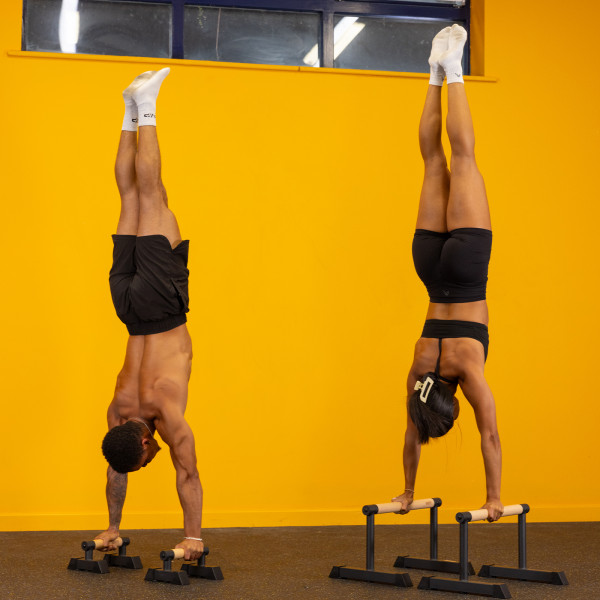 Gravity Fitness Travellettes - Lifestyle image - Two models performing handstands.