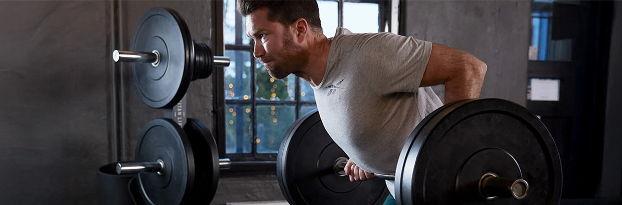 User performing bent-over row with the Gungnir The Curler EZ Curl Bar