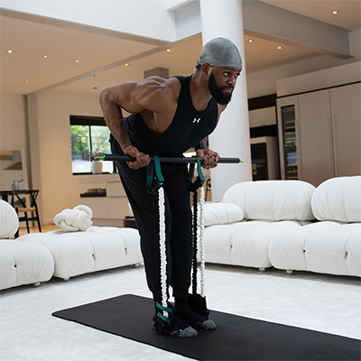 Model using the GymProLuxe portable gym to perform a bent-over row