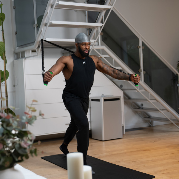Lifestyle image of a model using the GymProLuxe All-in-One Portable Gym at home