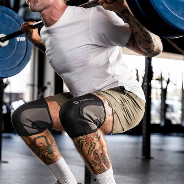 A closeup image of a model wearing Harbinger Pro 7mm Knee Sleeves during a barbell squat